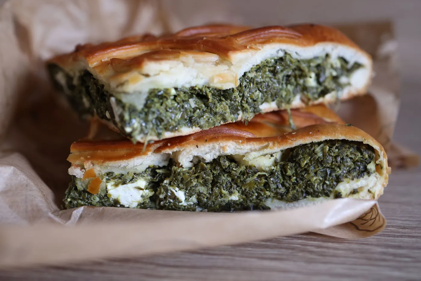 Presek kriške pite sa spanaćem i belim sirom na papiru za pečenje